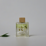 Clear glass bottle with wooden cap on a gray background