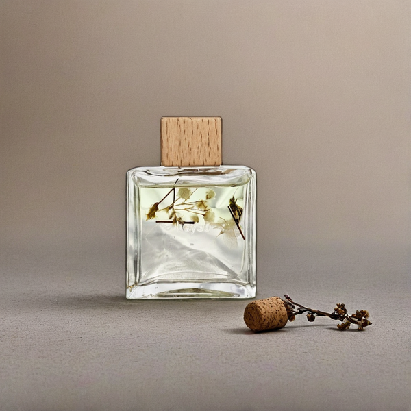 Clear glass perfume bottle with wooden cap and cork on a neutral background