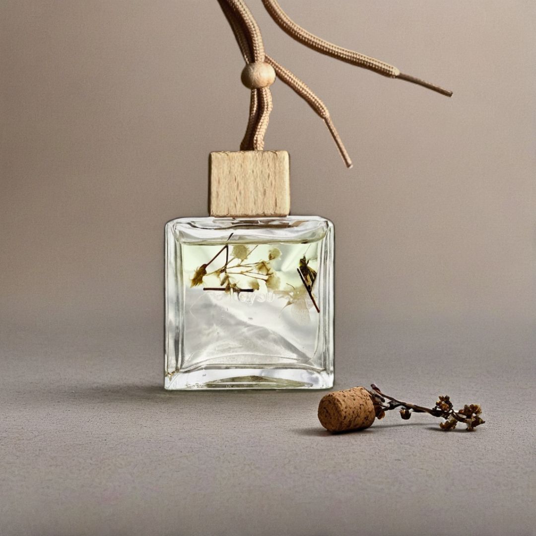 Clear glass diffuser bottle with wooden top and cork on a neutral background