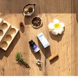 Essential oil bottle, box, and natural items on a wooden surface
