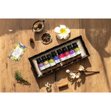 Set of small bottles with colorful labels on a wooden surface with decorative elements.