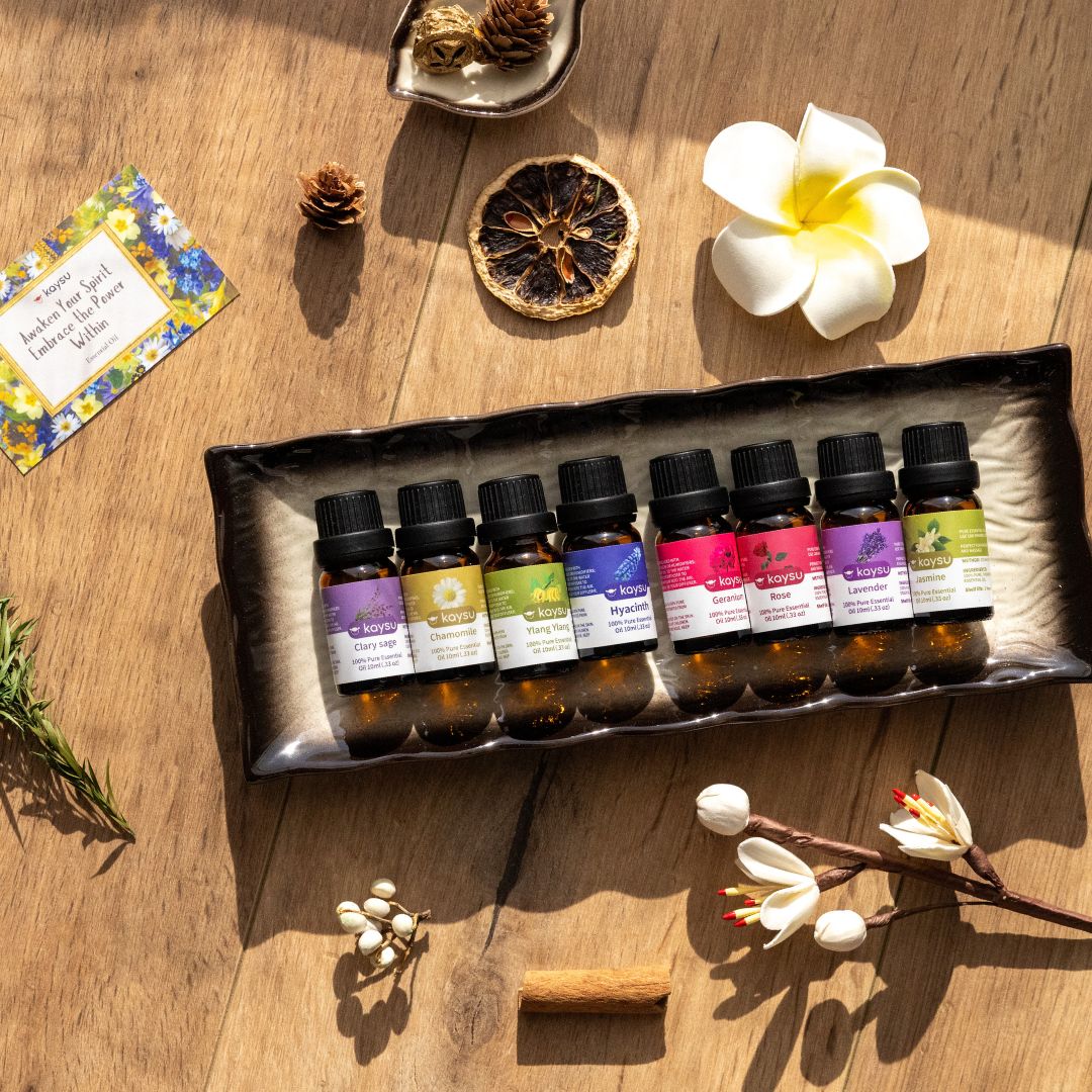  Essential oil bottles on a wooden surface with a flower and other items.