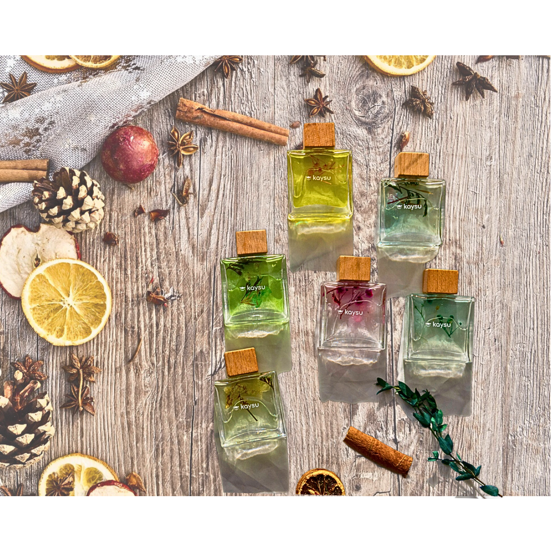 Perfume bottles with wooden caps on a rustic wooden surface with fruits and spices.